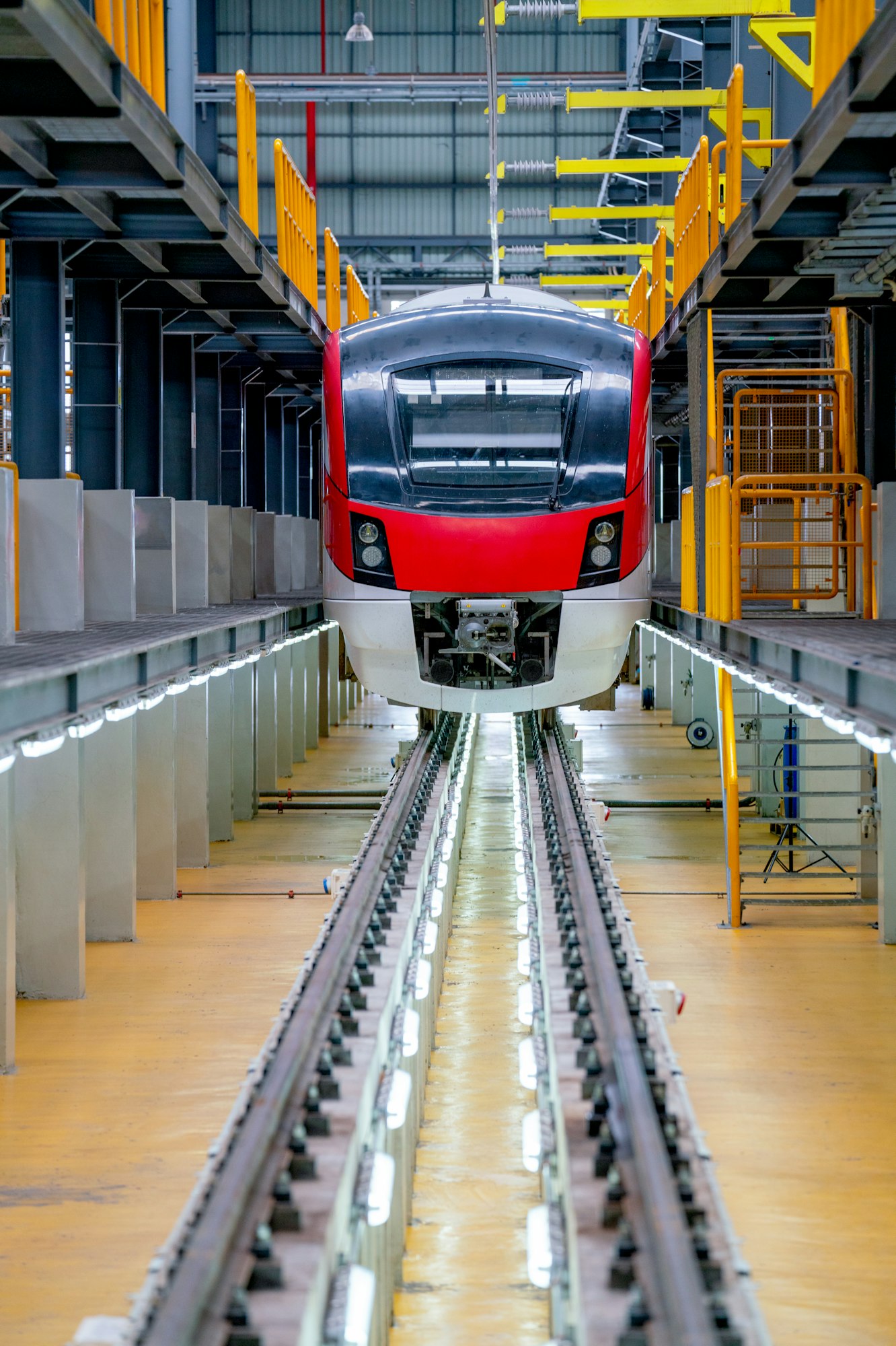 Vertical image of front electrical or metro train in the factory workplace with no people